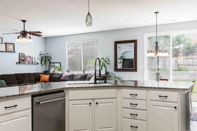 kitchen featuring a sink, stone countertops, open floor plan, white cabinetry, and dishwasher