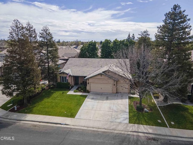 view of front of property with an attached garage, concrete driveway, and a front lawn