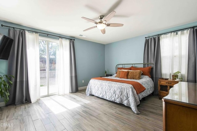 bedroom featuring access to exterior, wood finished floors, visible vents, and ceiling fan