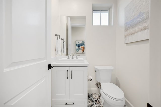 bathroom featuring baseboards, toilet, and vanity