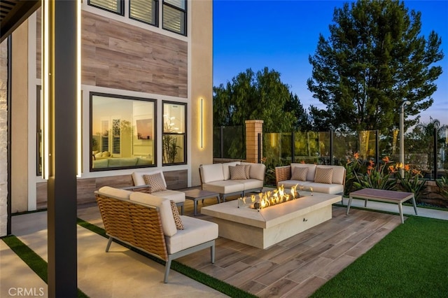 wooden deck featuring a patio area, an outdoor living space with a fire pit, and fence