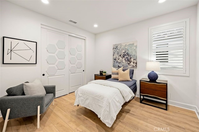 bedroom with light wood finished floors, visible vents, recessed lighting, and baseboards