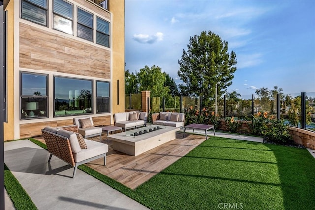 view of patio / terrace featuring an outdoor living space with a fire pit and fence