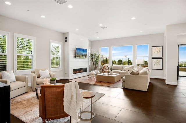 living room featuring visible vents, baseboards, dark tile patterned floors, recessed lighting, and a fireplace