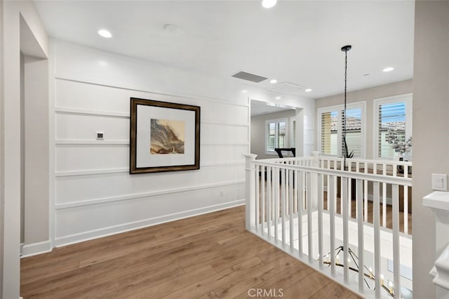 hall with visible vents, baseboards, an upstairs landing, recessed lighting, and wood finished floors