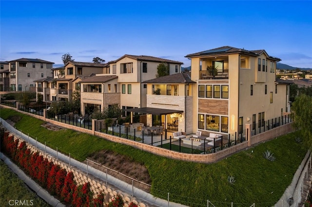 rear view of property with a residential view, a balcony, and fence