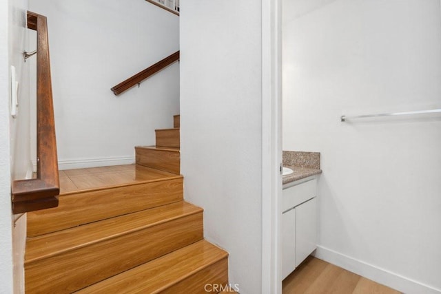 stairway with wood finished floors and baseboards