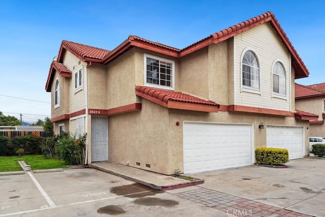 view of front of home featuring stucco siding, an attached garage, and a tile roof