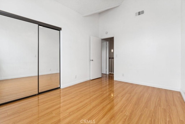 unfurnished bedroom featuring visible vents, baseboards, and wood finished floors