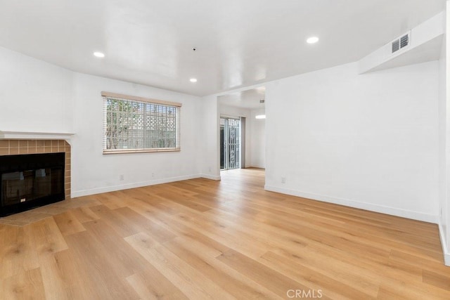 unfurnished living room featuring visible vents, light wood-style flooring, recessed lighting, a fireplace, and baseboards