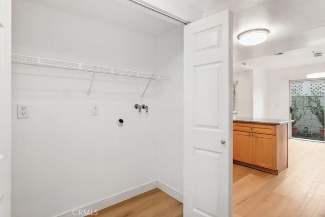 laundry room featuring visible vents, hookup for a washing machine, light wood-style flooring, and baseboards