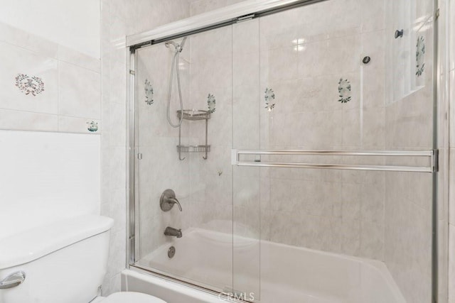 full bath featuring combined bath / shower with glass door and toilet