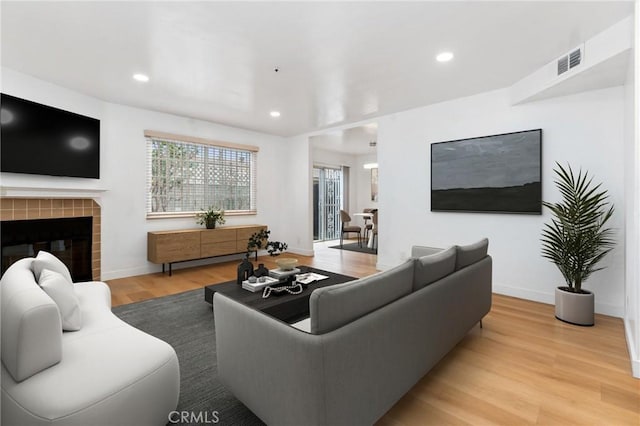 living area featuring recessed lighting, visible vents, baseboards, and wood finished floors