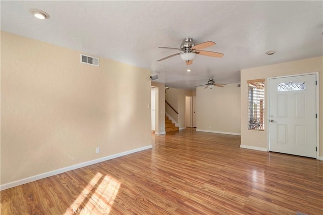 interior space featuring visible vents, stairway, light wood-type flooring, and a ceiling fan