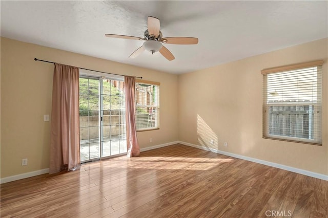 empty room featuring a ceiling fan, wood finished floors, and baseboards