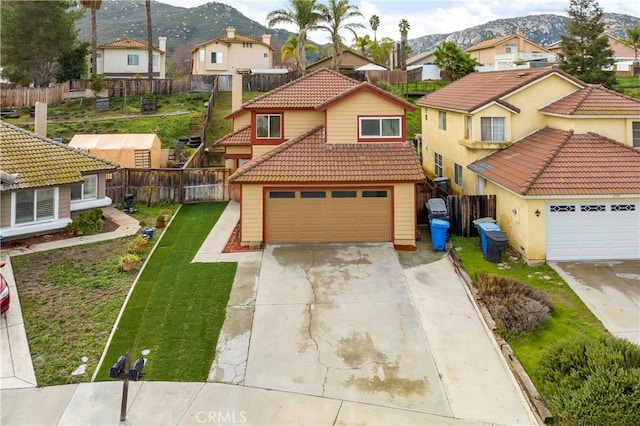 mediterranean / spanish home with fence, concrete driveway, a garage, a tiled roof, and a residential view