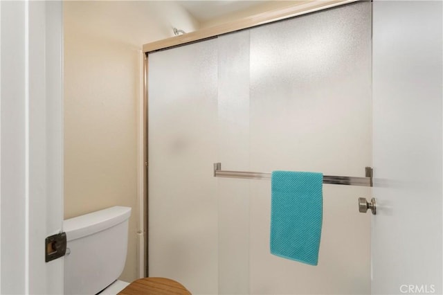 full bathroom featuring toilet and a stall shower