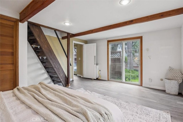 bedroom with access to exterior, baseboards, beamed ceiling, recessed lighting, and wood finished floors