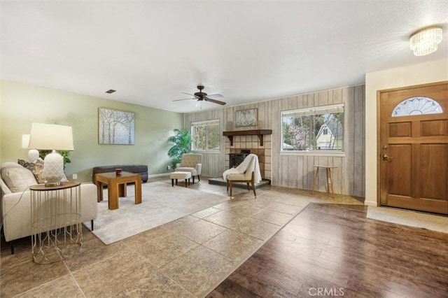 living room with baseboards, wood finished floors, visible vents, and ceiling fan