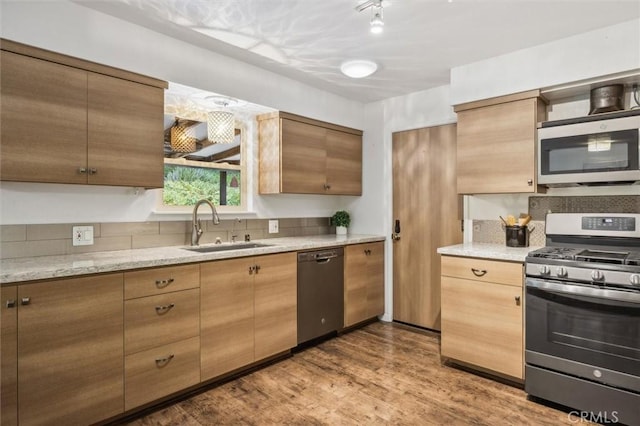 kitchen with a sink, stainless steel appliances, and wood finished floors