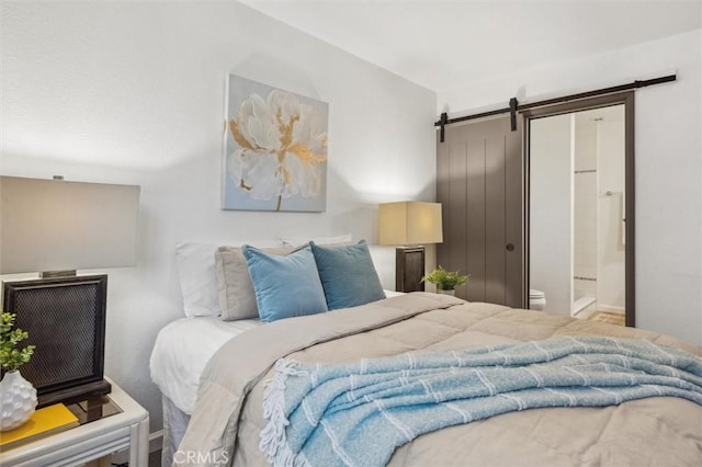 bedroom with a barn door and ensuite bathroom