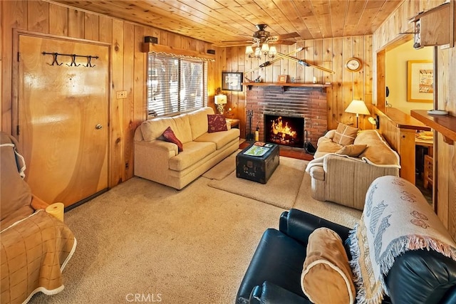 carpeted living room with wooden walls, a fireplace, wood ceiling, and ceiling fan