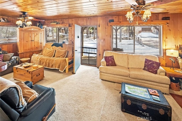 carpeted living room featuring wooden walls, wood ceiling, and ceiling fan