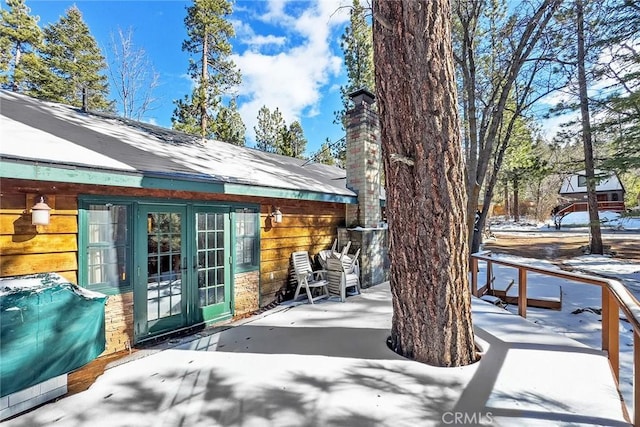 snow covered patio with grilling area and french doors