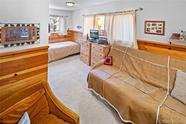 carpeted bedroom featuring wood walls