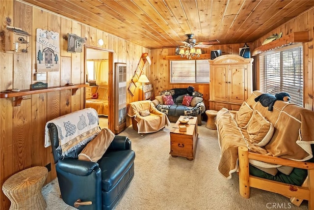 carpeted living area featuring wooden walls, wooden ceiling, and ceiling fan