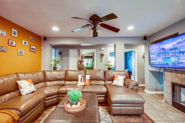 living area with light tile patterned floors, recessed lighting, a ceiling fan, and a tile fireplace