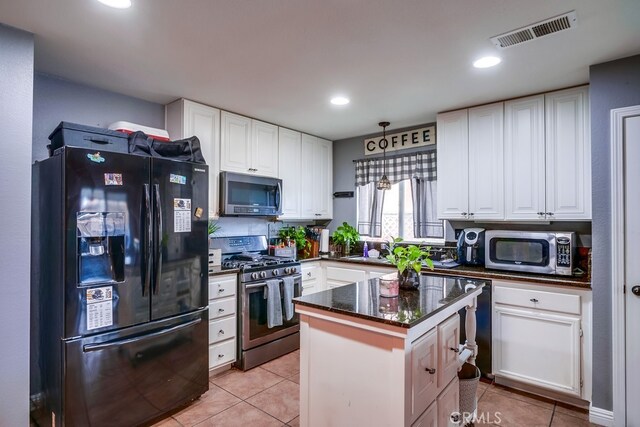 kitchen with light tile patterned floors, stainless steel appliances, visible vents, and white cabinets