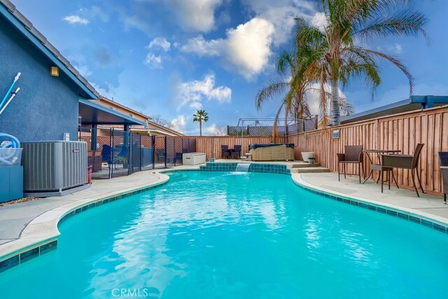 view of pool with a patio area, cooling unit, a fenced backyard, and a fenced in pool