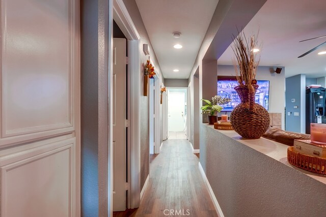 corridor with recessed lighting, wood finished floors, and baseboards