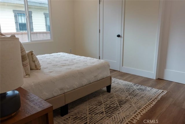 bedroom with wood finished floors and baseboards