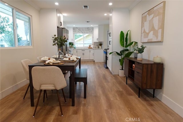 dining room featuring light wood-type flooring, baseboards, visible vents, recessed lighting, and crown molding