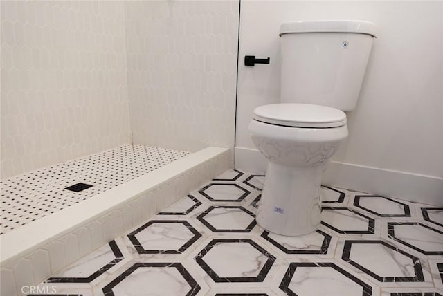 bathroom with walk in shower, toilet, and baseboards