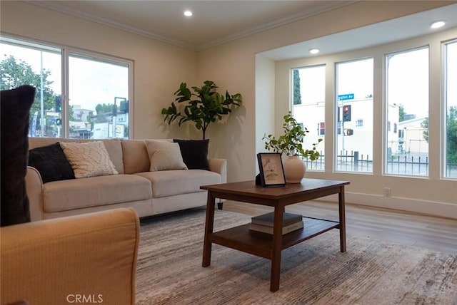 living room featuring recessed lighting, baseboards, crown molding, and light wood-style floors