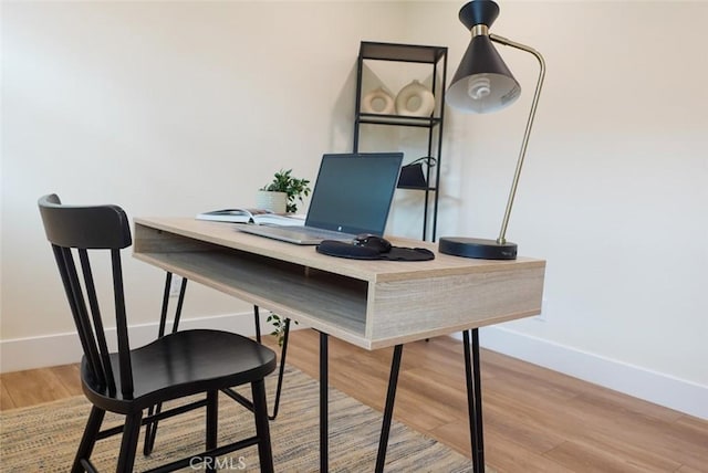 office area with light wood-type flooring and baseboards