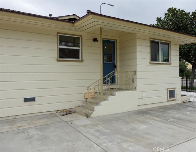 entrance to property with fence and a patio