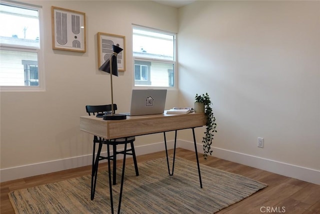office space with baseboards, wood finished floors, and a wealth of natural light