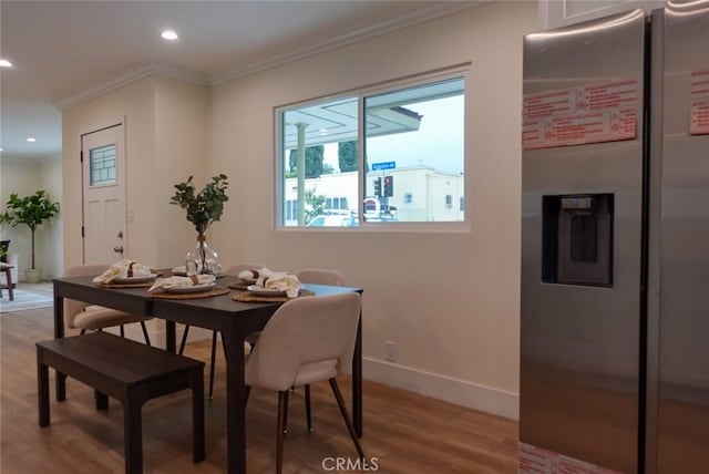 dining space featuring baseboards, crown molding, light wood finished floors, and recessed lighting