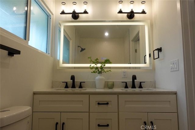 full bathroom featuring double vanity, toilet, and a sink