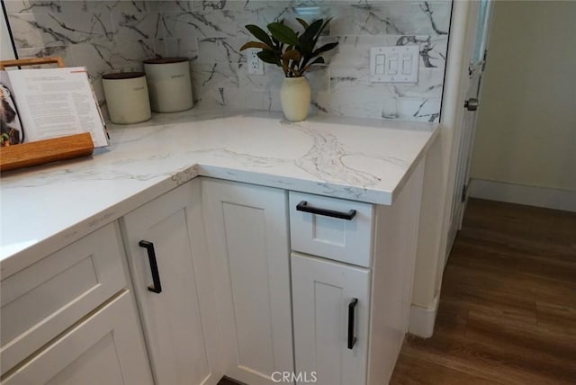 interior details featuring tasteful backsplash, baseboards, and wood finished floors