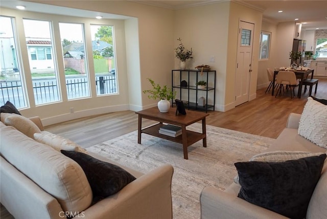 living room with crown molding, recessed lighting, light wood-type flooring, and baseboards