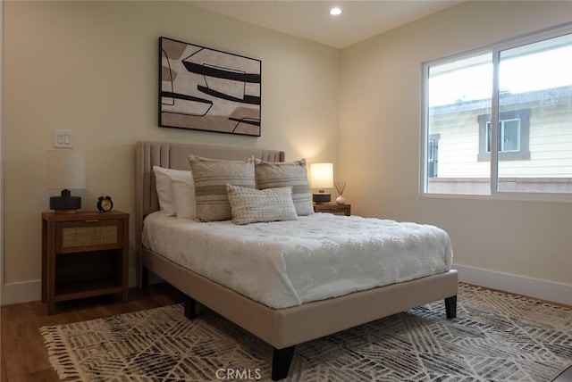 bedroom with baseboards, wood finished floors, and recessed lighting