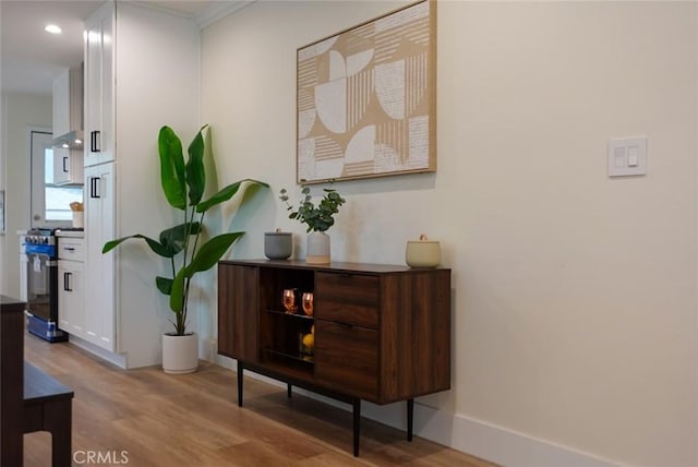 hall featuring baseboards, wood finished floors, and recessed lighting