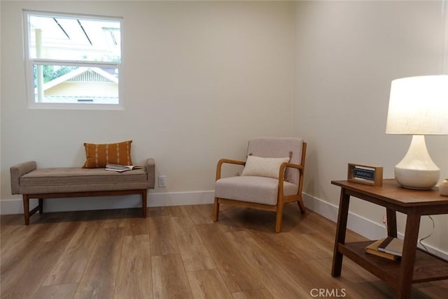 living area featuring light wood finished floors and baseboards