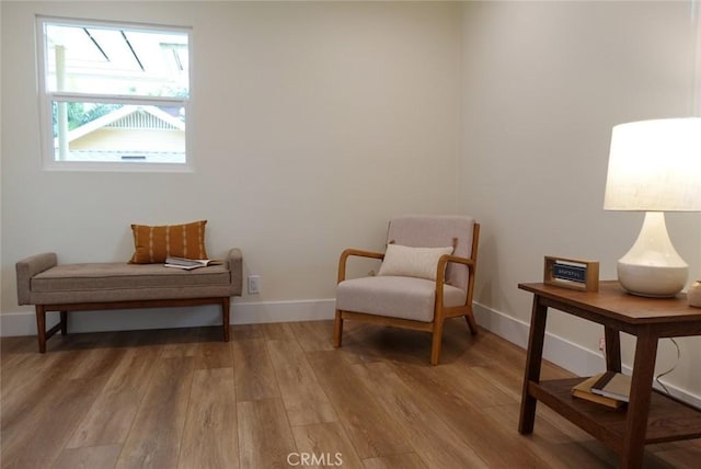 living area with baseboards and wood finished floors