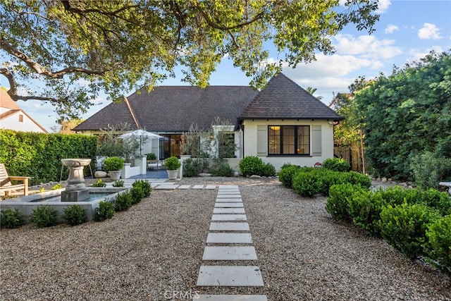 view of front of property with roof with shingles and stucco siding